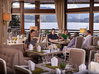Clientes disfrutando de una comida en el restaurante con vista panorámica al lago Titisee