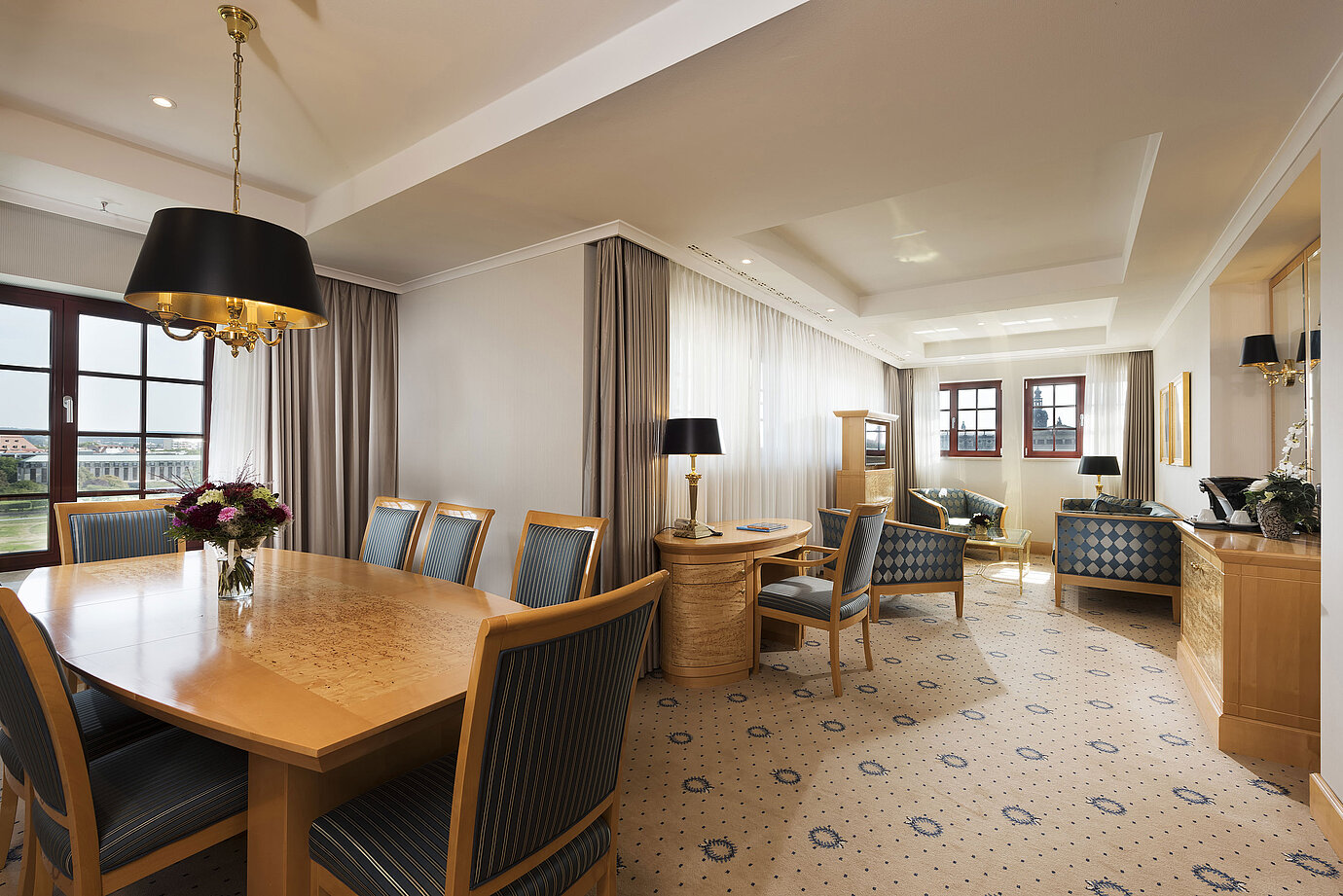 Spacious Executive Suite at Maritim Hotel Dresden with elegant dining table, comfortable seating area, and city view.