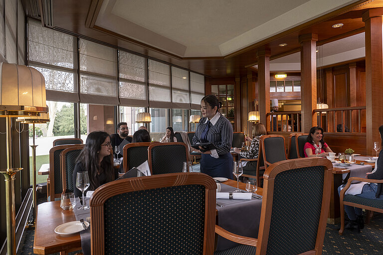 Les clients dînent dans le restaurant élégant du Maritim Hotel Bad Homburg, avec un service attentionné du personnel.