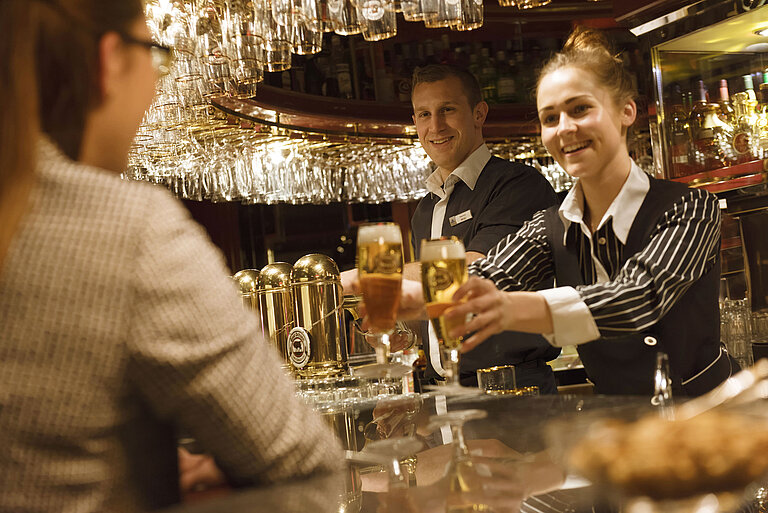 Deux employés servent des boissons fraîches au bar de l’hôtel Maritim Ulm