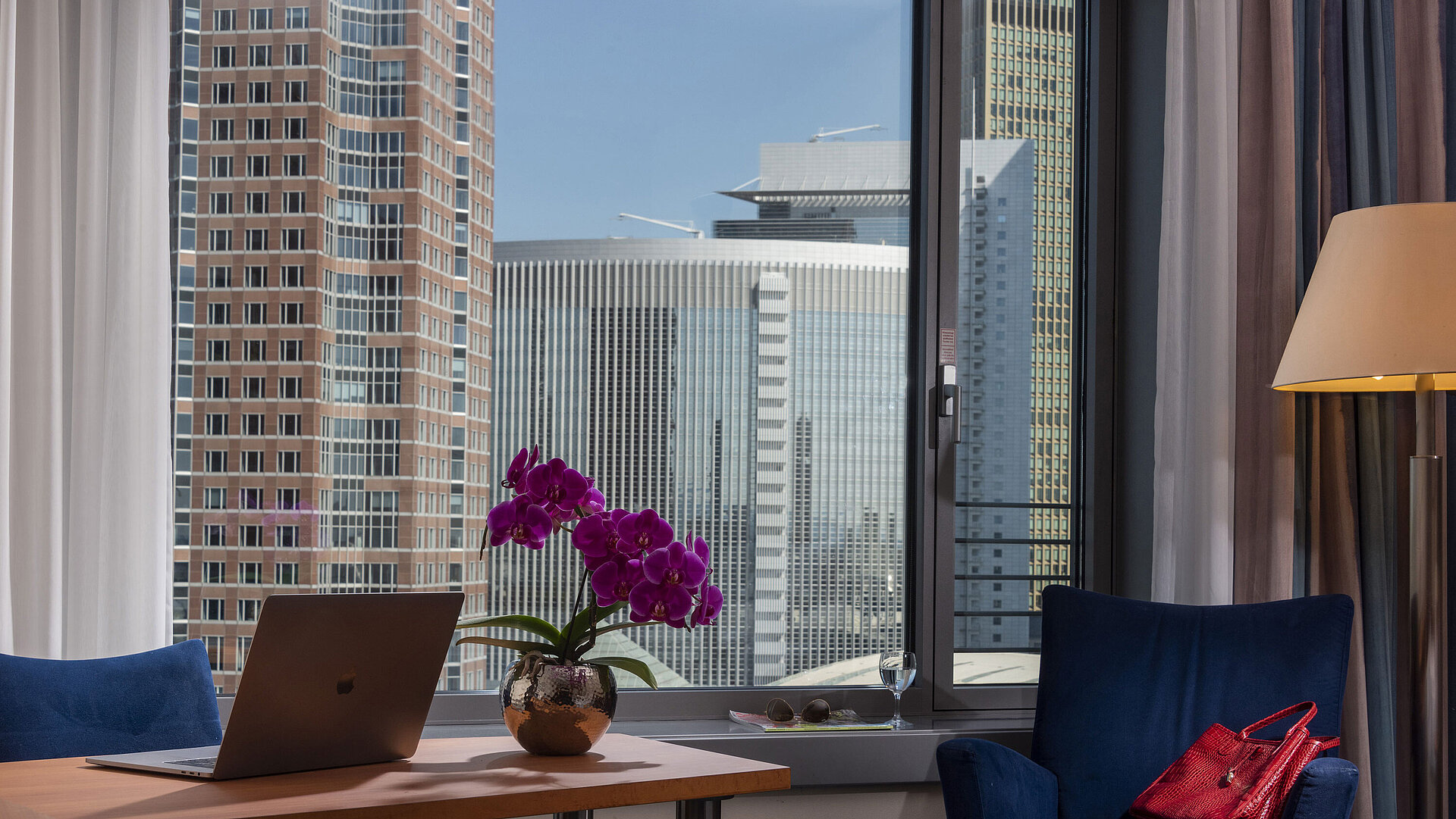 Superior room at Maritim Hotel Frankfurt with panoramic skyline view, desk, and elegant seating area.