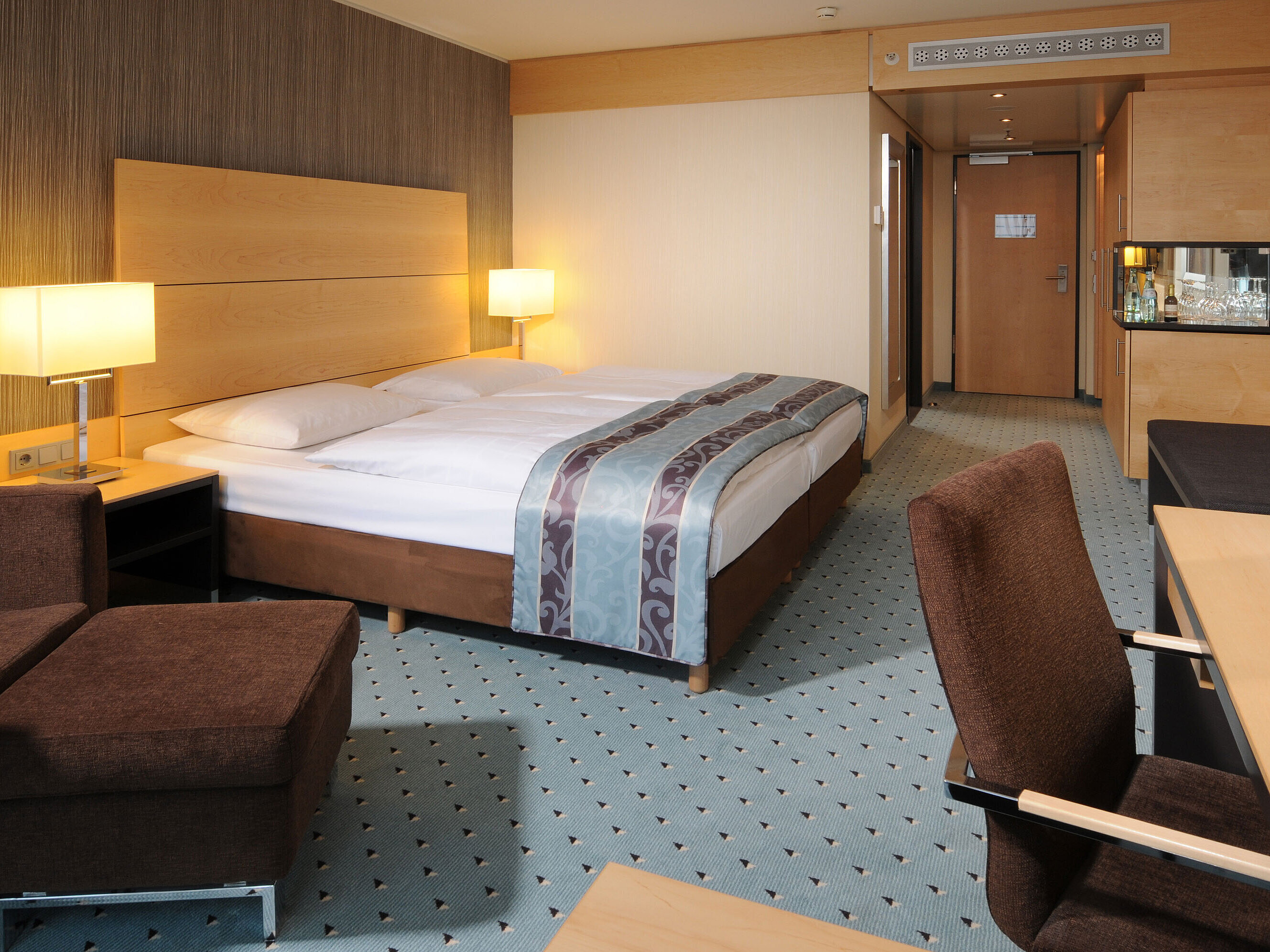 Classic room at Maritim Hotel Düsseldorf with a comfortable double bed, modern amenities, seating area, and bright lighting.