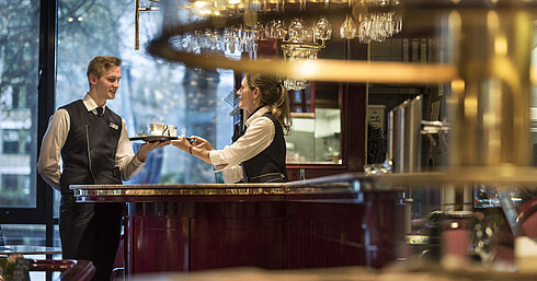  Personal amable en el bar de la Brasserie del Maritim Hotel Bonn, ofreciendo servicio de bebidas con una sonrisa.