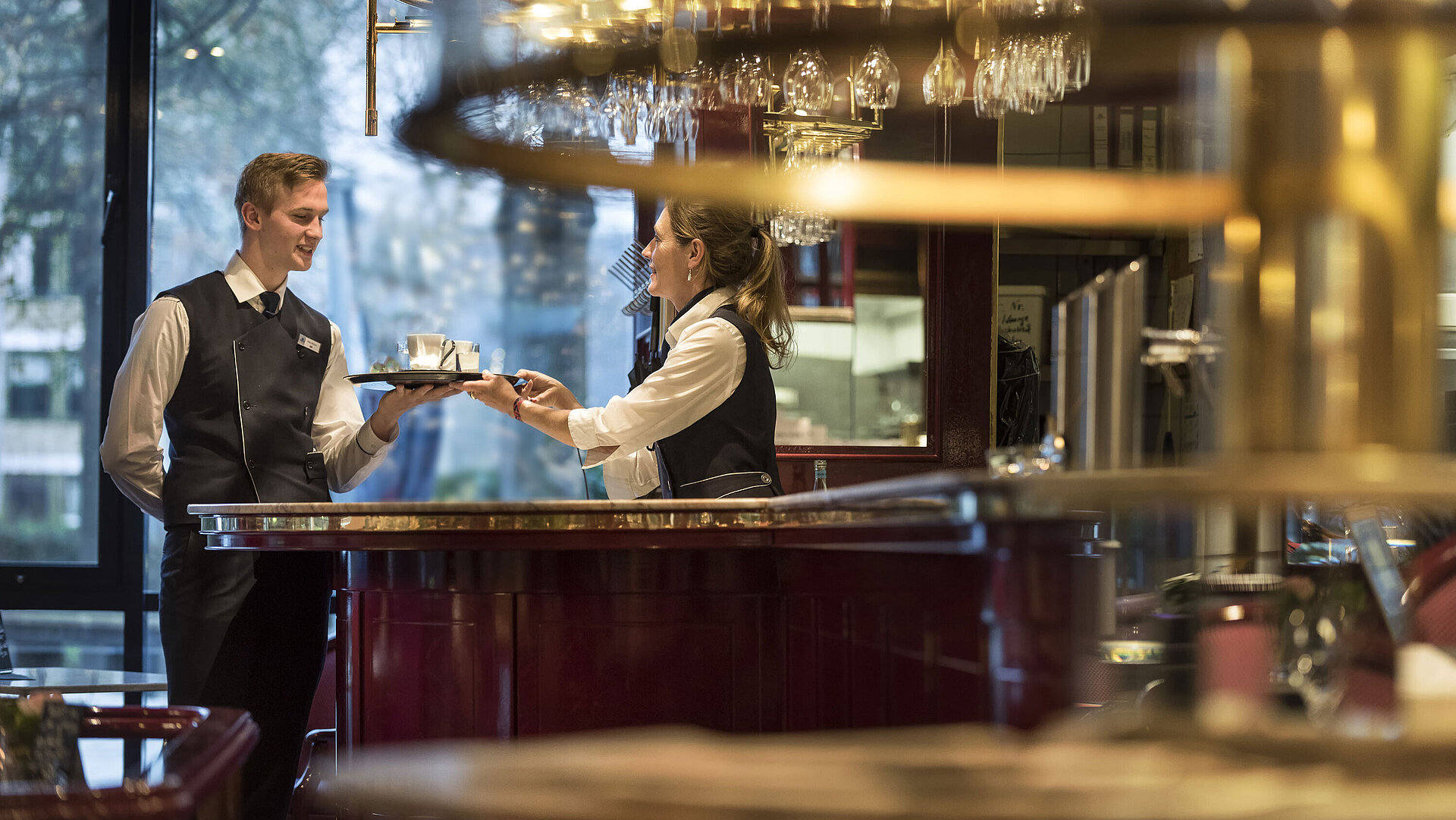 Friendly service staff at the Brasserie bar of Maritim Hotel Bonn, offering beverage service with a smile.