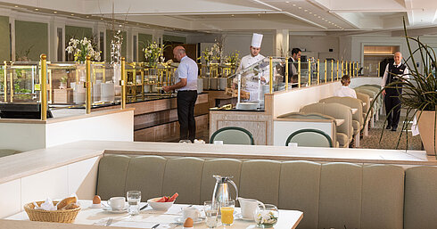 Bufé de desayuno en el Maritim Hotel Würzburg con clientes, cocineros y amplia variedad