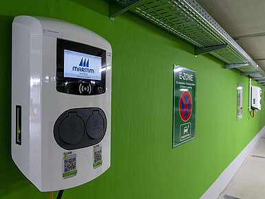 Close-up of an electric vehicle charging station with the Maritim Hotels logo in the E-Zone of the parking garage.