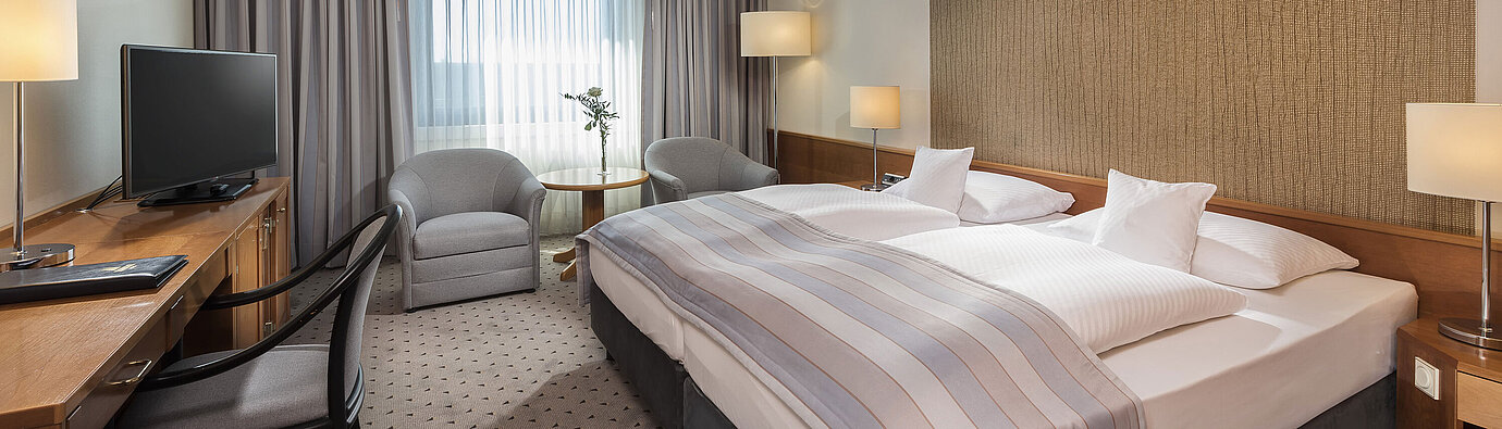 Classic room  Modern classic double room with a cozy double bed, seating area, and desk at Maritim Hotel Hannover.