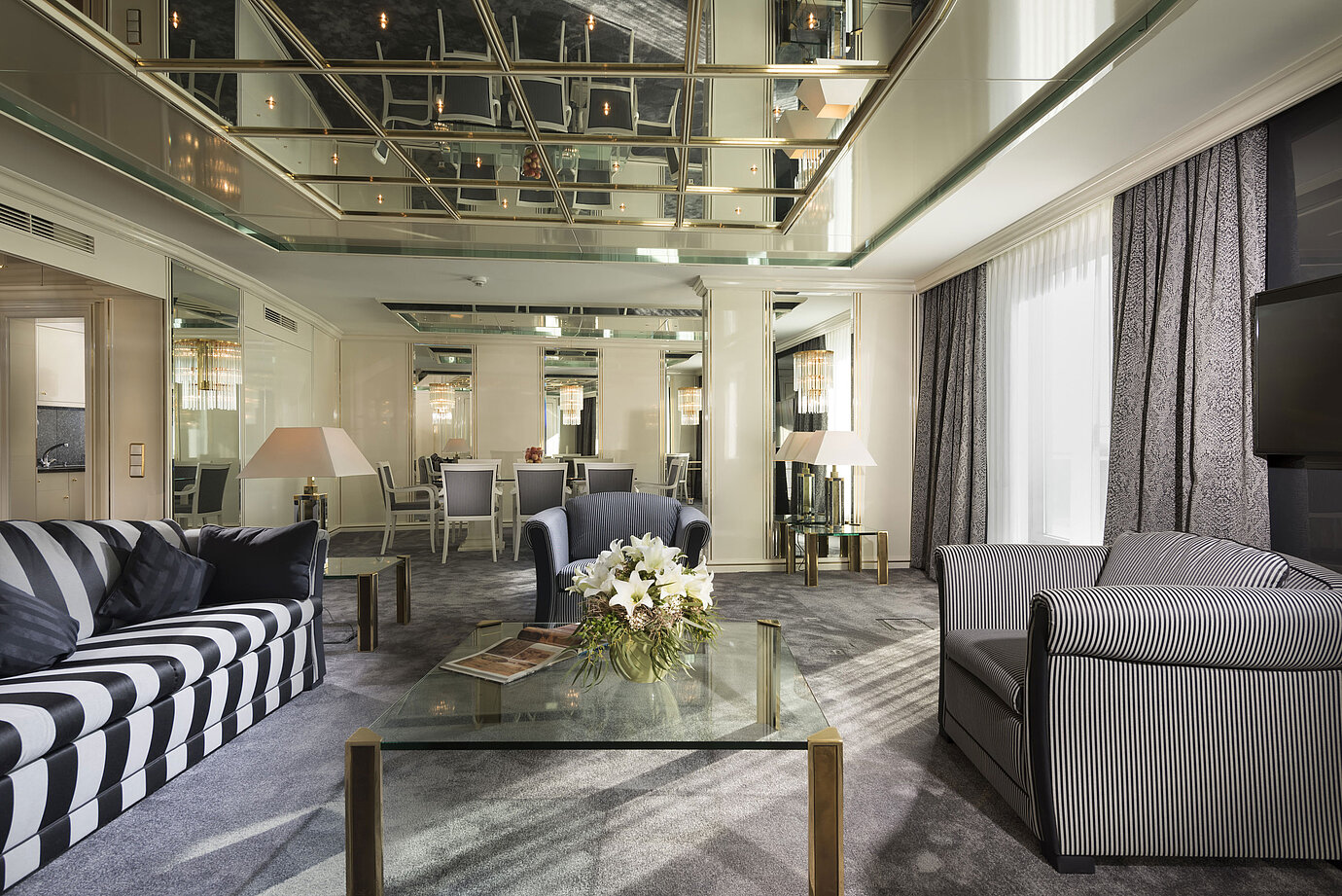 Suite de luxe au Maritim Hotel Ulm avec plafond en miroir, coin salon élégant et table à manger
