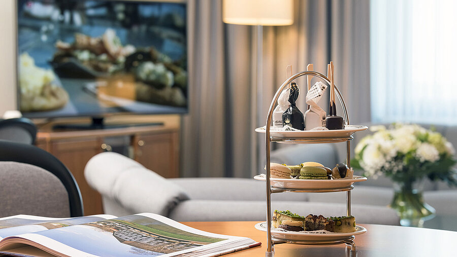Sala de estar elegante con bandeja de dulces en la Junior Suite del Maritim Hotel Hannover.