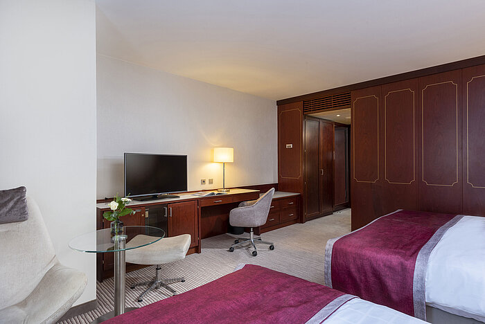 Habitación familiar en el Hotel Maritim Bonn con comodidades modernas, camas cómodas y escritorio práctico.