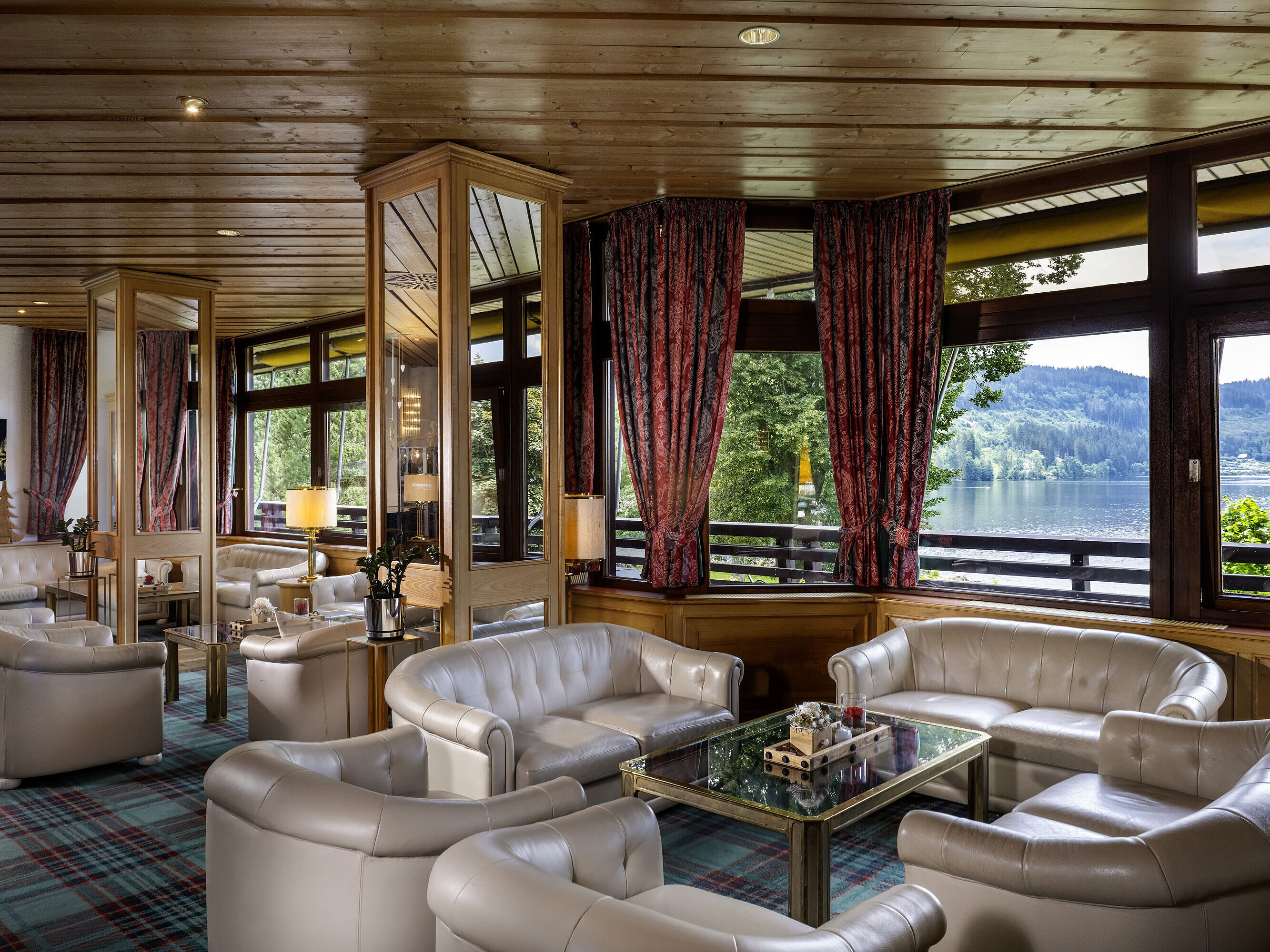 Lobby luminosa con sillones de cuero y vistas al lago en el Maritim Hotel Titisee