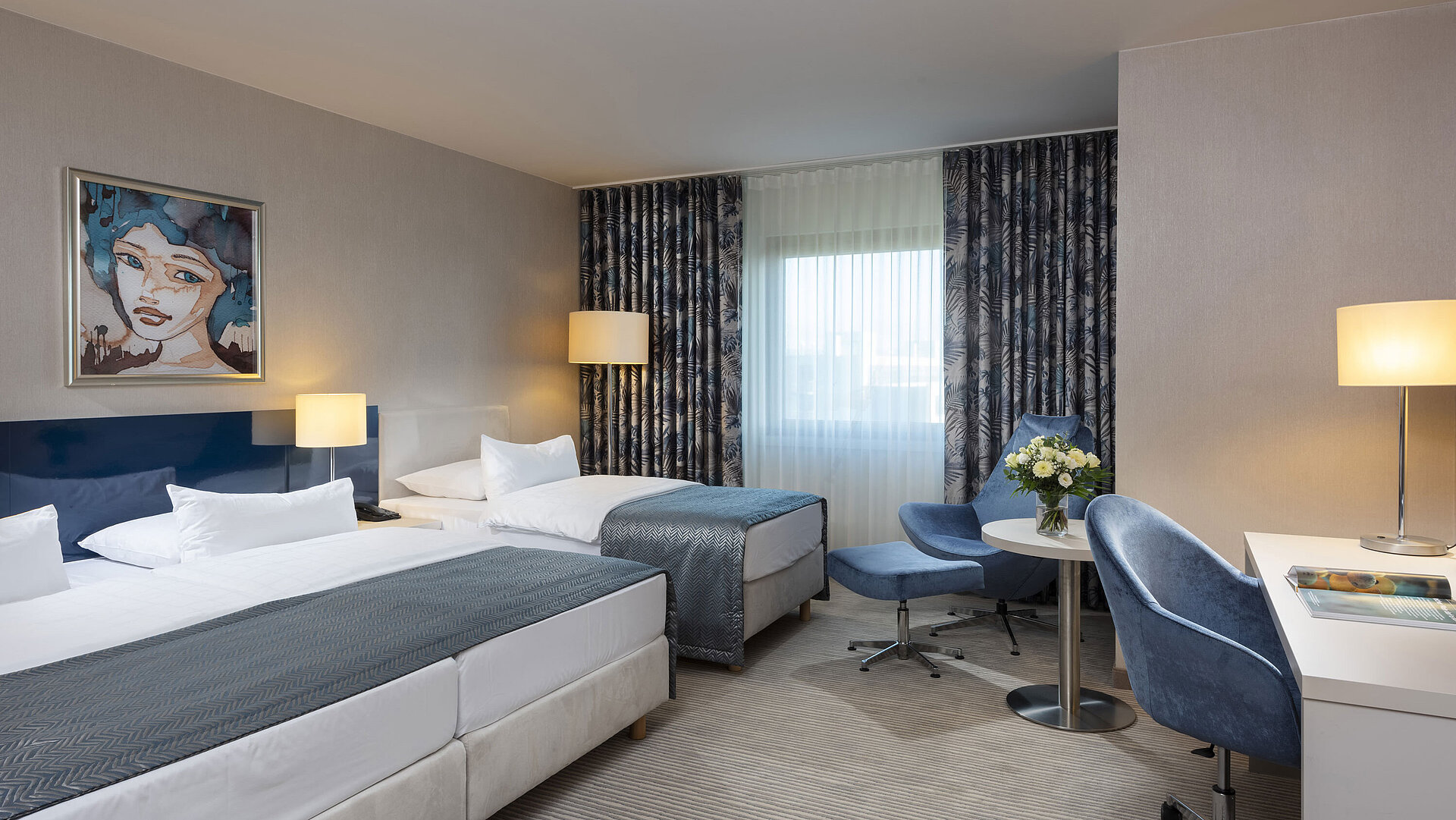 Family room at the Maritim Hotel Bonn with a double bed, single bed, desk, cozy seating area and modern design.