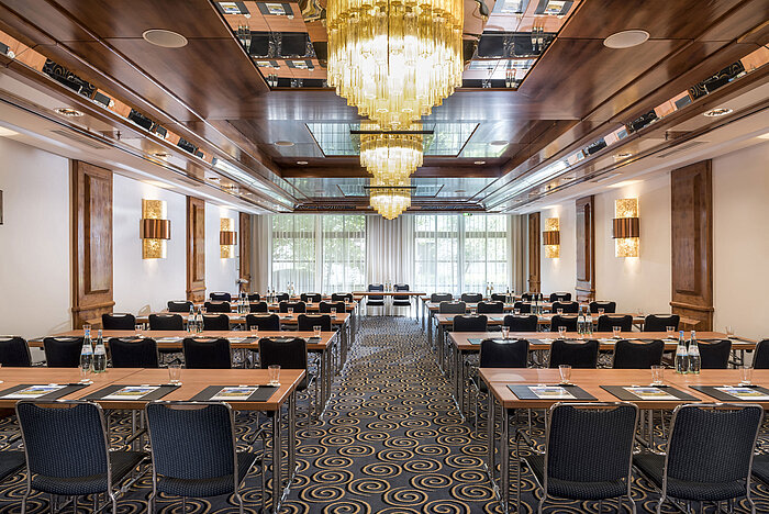 Salle de réunion élégante avec grands lustres, lumière naturelle et sièges modernes au Maritim Hotel Königswinter.