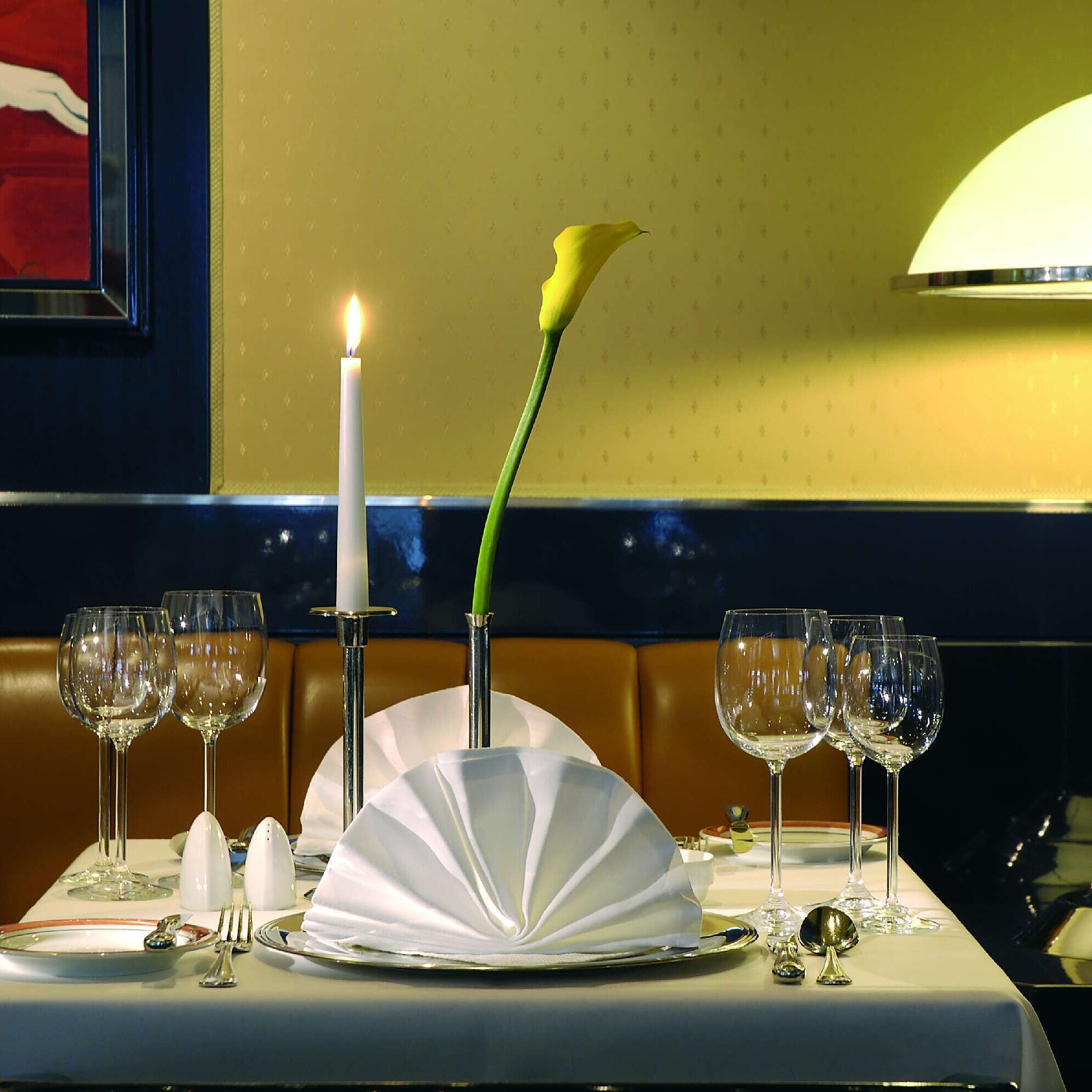Set table with candle and wine glasses at Maritim Hotel Magdeburg restaurant