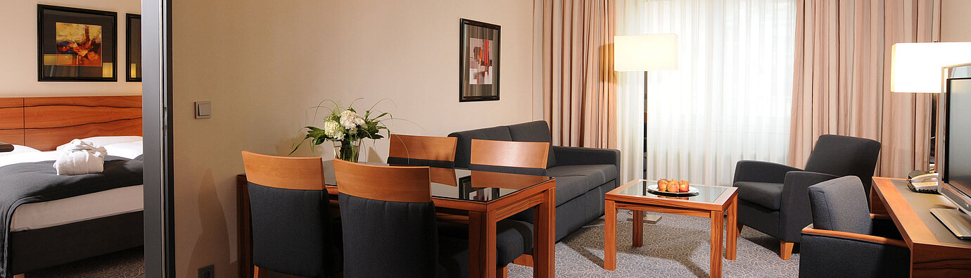 Suite amplia con salón, mesa de comedor y dormitorio independiente en Maritim Hotel Múnich