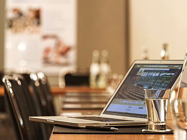 Laptop, pen and glass of water on table in the conference room at the Maritim Hotel Munich