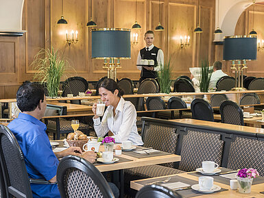 Huéspedes disfrutando del buffet de desayuno en el restaurante "Rôtisserie" del Maritim Hotel Bonn con platos recién preparados.