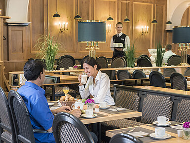 Ospiti che gustano il buffet della colazione al ristorante "Rôtisserie" del Maritim Hotel Bonn con piatti preparati al momento.