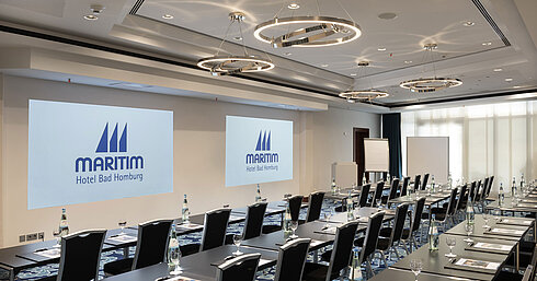 Salle de conférence moderne à l'hôtel Maritim Bad Homburg avec sièges et projection.