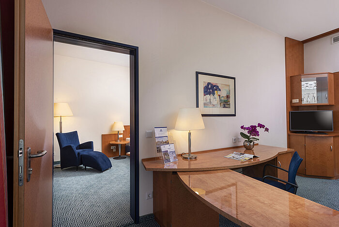Chambre familiale Confort du Maritim Hotel Frankfurt avec espace salon et chambre séparés, bureau et intérieur élégant.