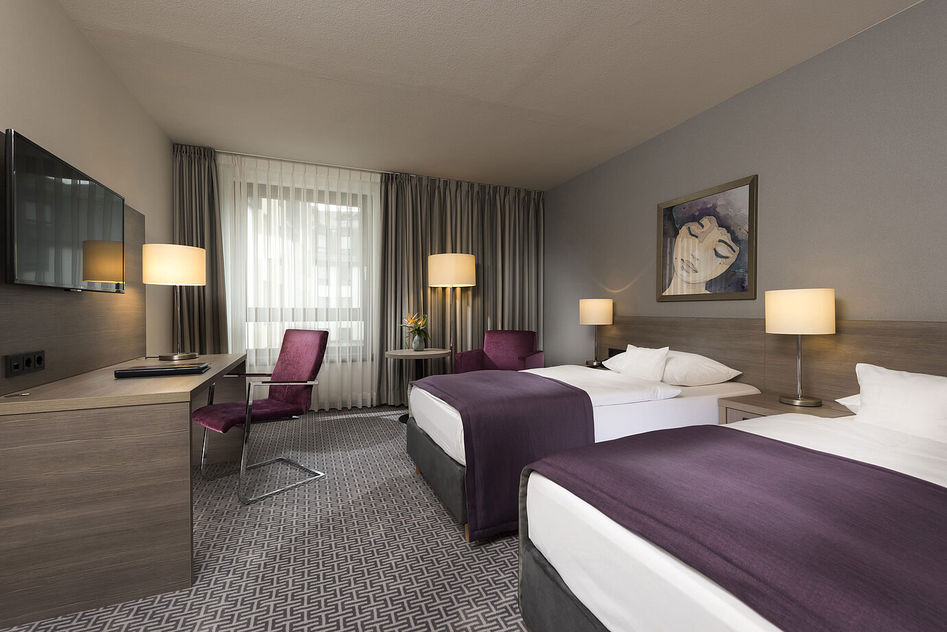 Habitación doble moderna del Maritim Hotel Königswinter con dos camas, escritorio y decoración elegante.