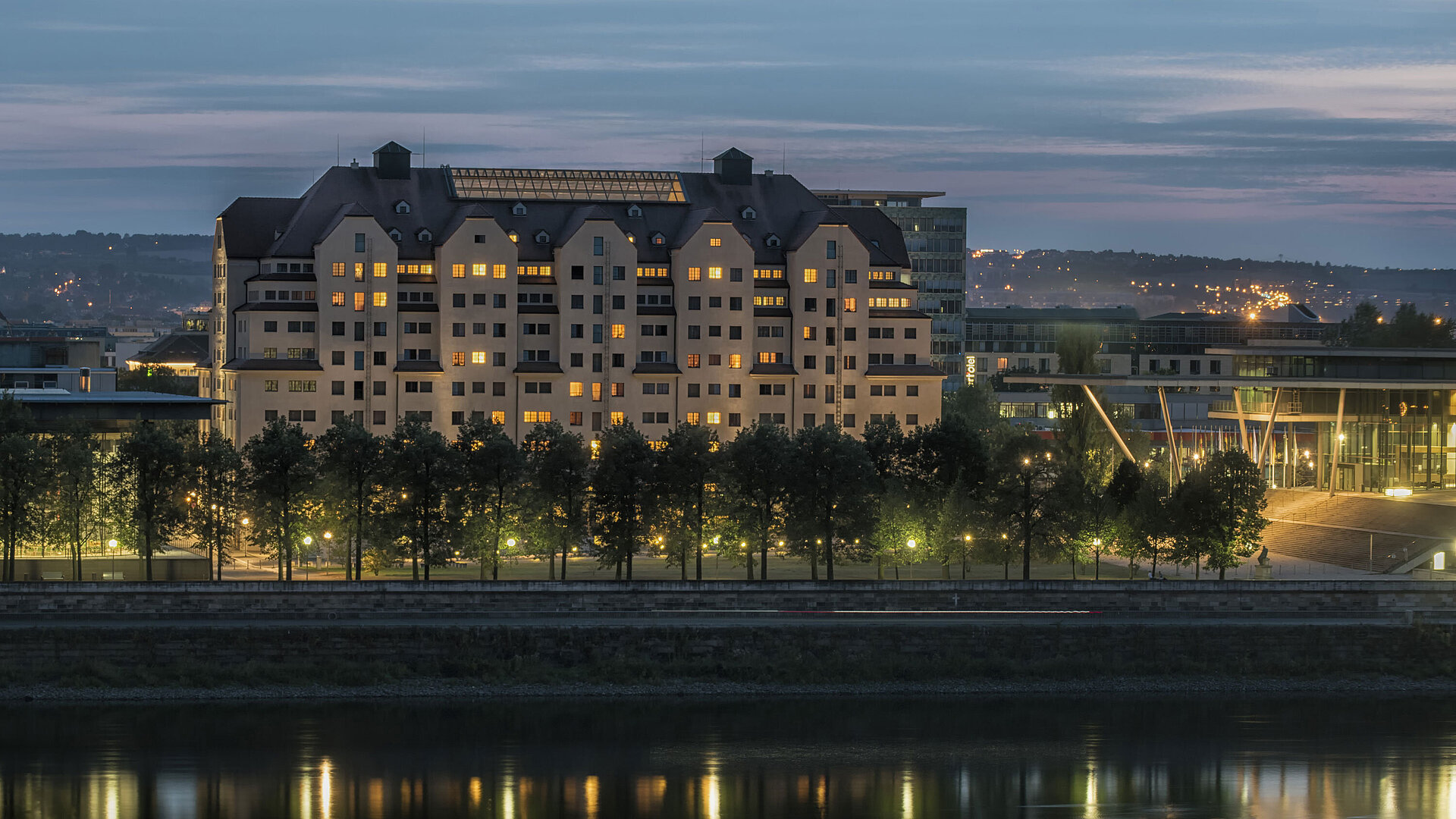 Vue extérieure la nuit Hôtel Maritim de Dresde illuminé au crépuscule avec des lumières se reflétant sur l'Elbe.