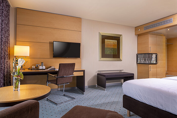 Habitación clásica en el Maritim Hotel Düsseldorf con escritorio, televisor de pantalla plana, decoración elegante y ambiente acogedor.