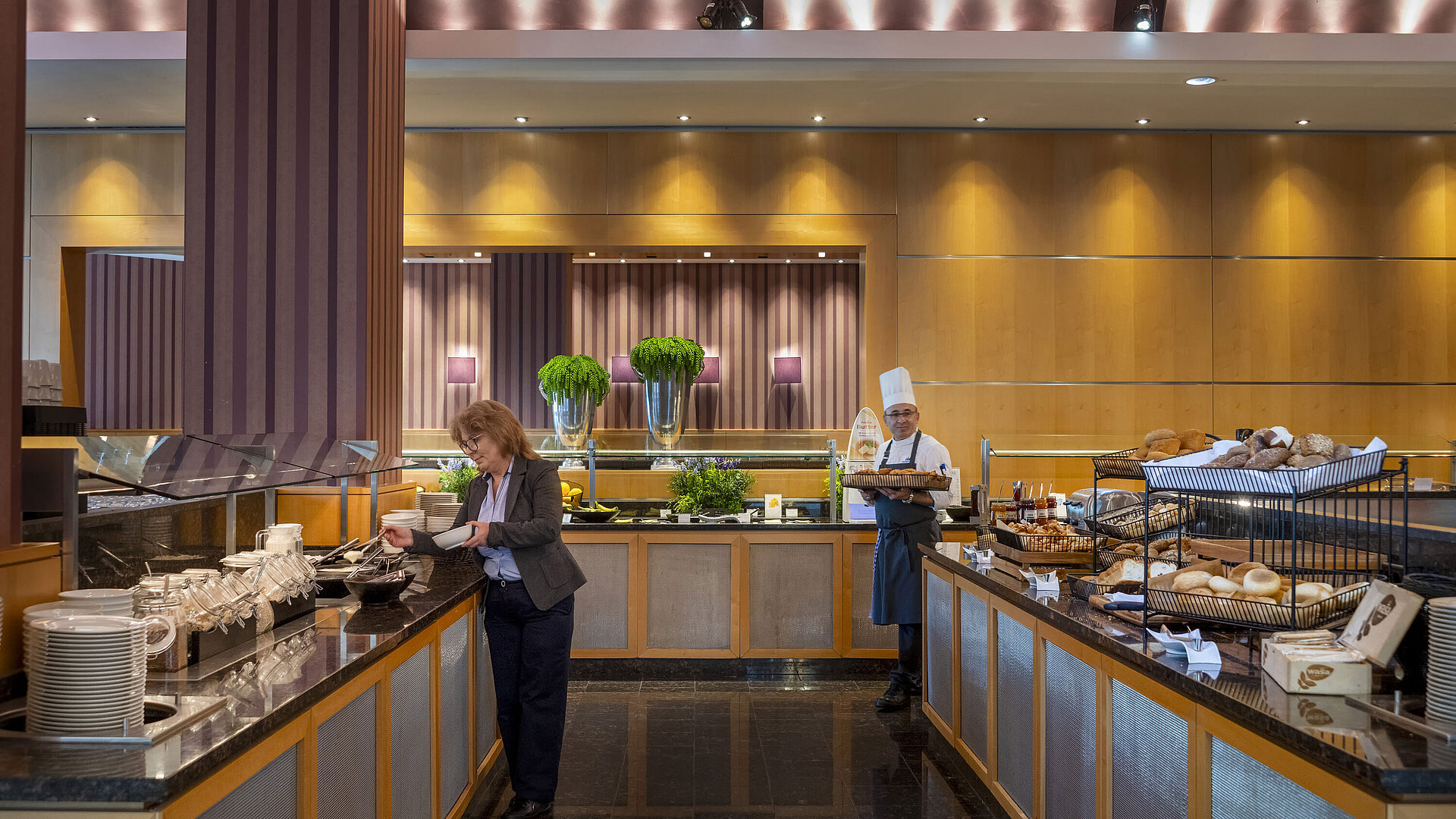 Breakfast buffet at Maritim Hotel Düsseldorf with freshly baked bread, hot dishes, and a chef serving guests.