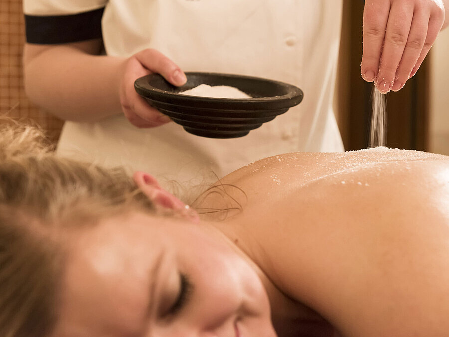 Gros plan d’un traitement au sel sur le dos au spa du Maritim Seehotel Timmendorfer Strand.