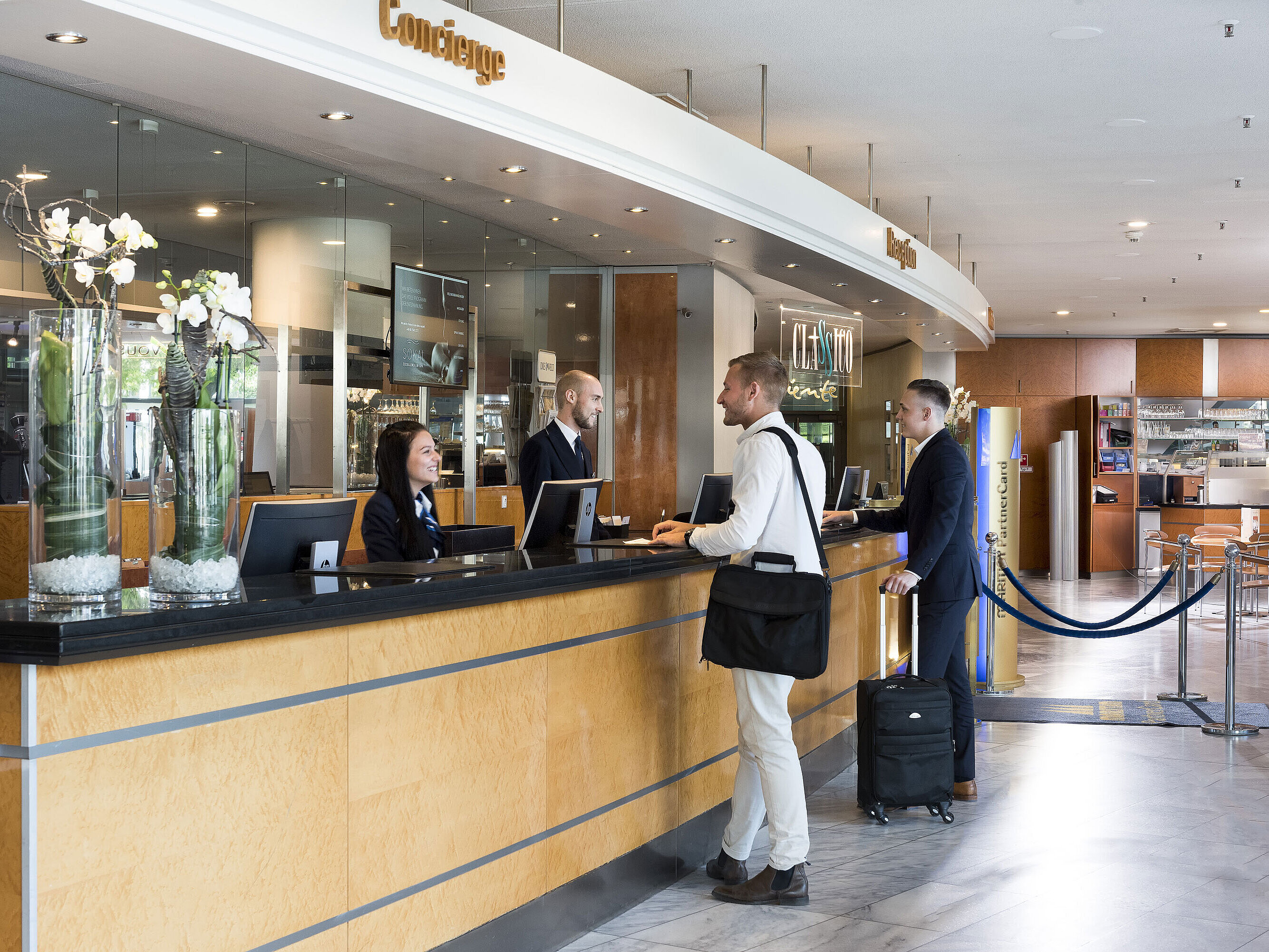 Accoglienza cordiale alla reception del Maritim Hotel Frankfurt con ospiti e personale in una lobby moderna.