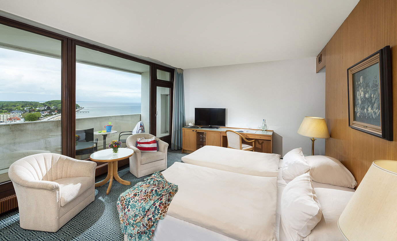 Comfortable room with two armchairs and sea view balcony at Maritim Hotel Travemünde