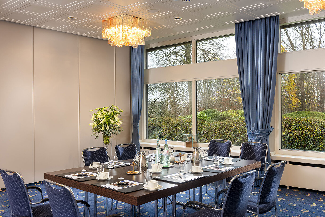 Salon Flensburg del Maritim Hotel Kiel, sala conferenze con tavolo apparecchiato, grandi finestre e illuminazione elegante.