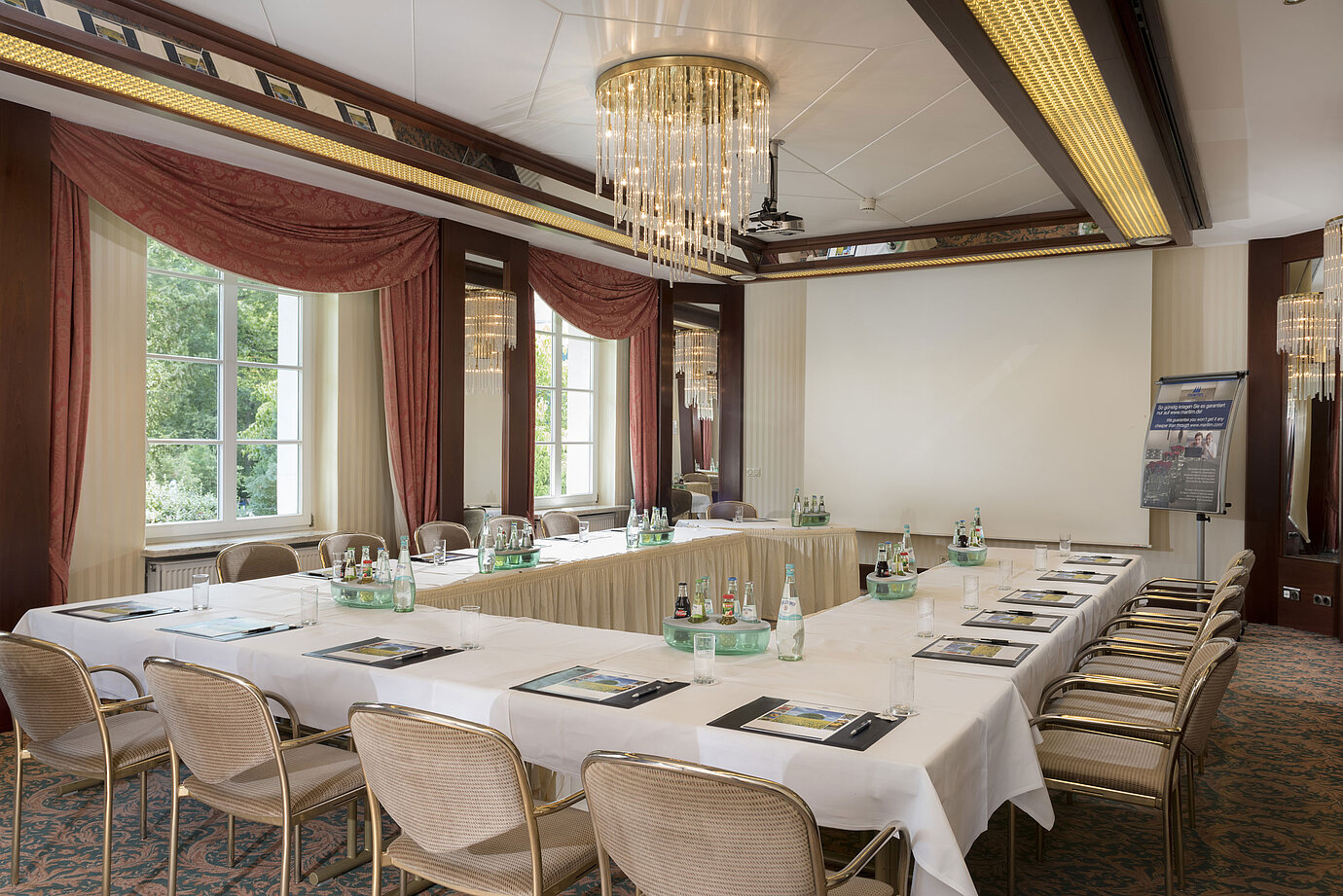 Salle de réunion lumineuse avec disposition en U, fenêtres et lustre au Maritim Hotel Bad Wildungen