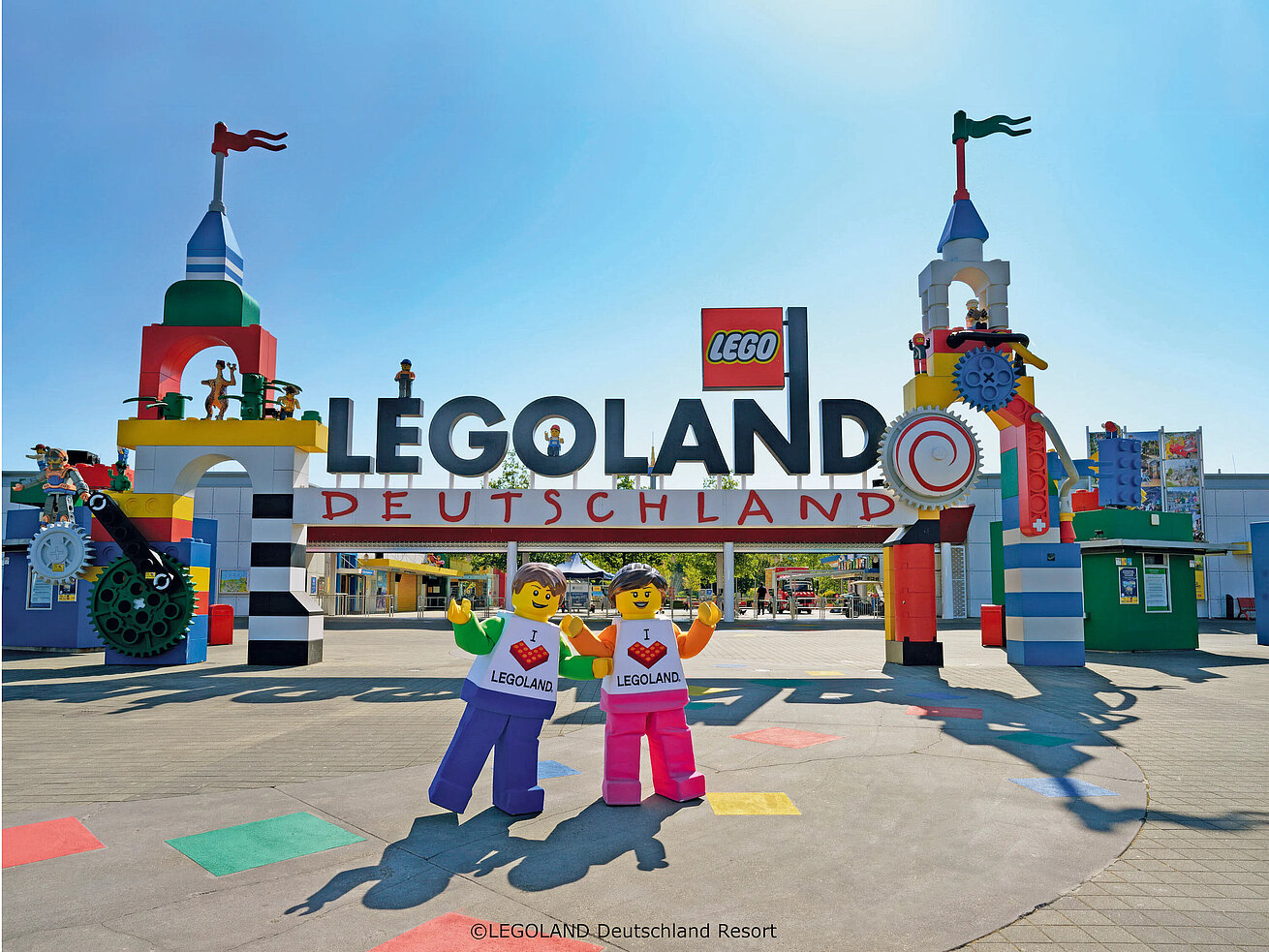Área de entrada de LEGOLAND® Deutschland Resort Entrada colorida de LEGOLAND® Deutschland Resort con figuras LEGO® gigantes y cielo azul.