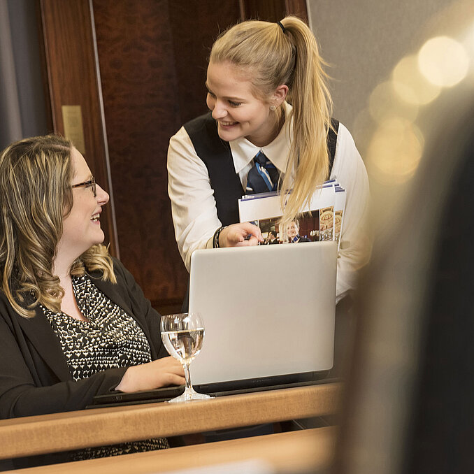 A Maritim Hotel Bonn employee assists a participant during a meeting in Salon Rheinaue.