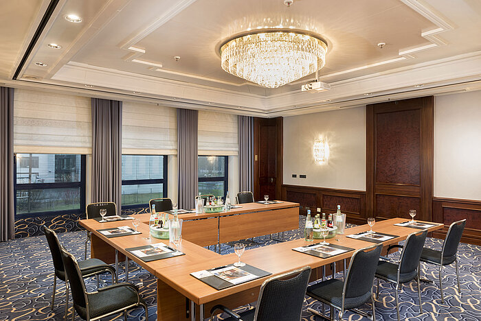 Salón Rheinaue en el Hotel Maritim Bonn, preparado para una conferencia con disposición en U, equipado con bebidas y materiales. 