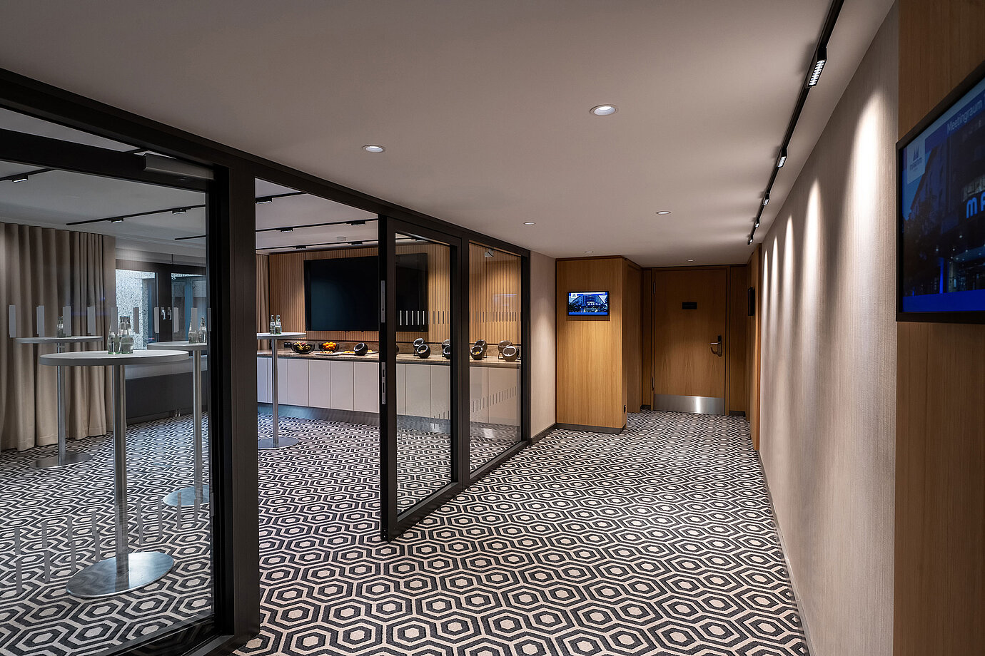 Zona de pausa para café moderna con mesas altas, estación de café y ambiente elegante para reuniones.