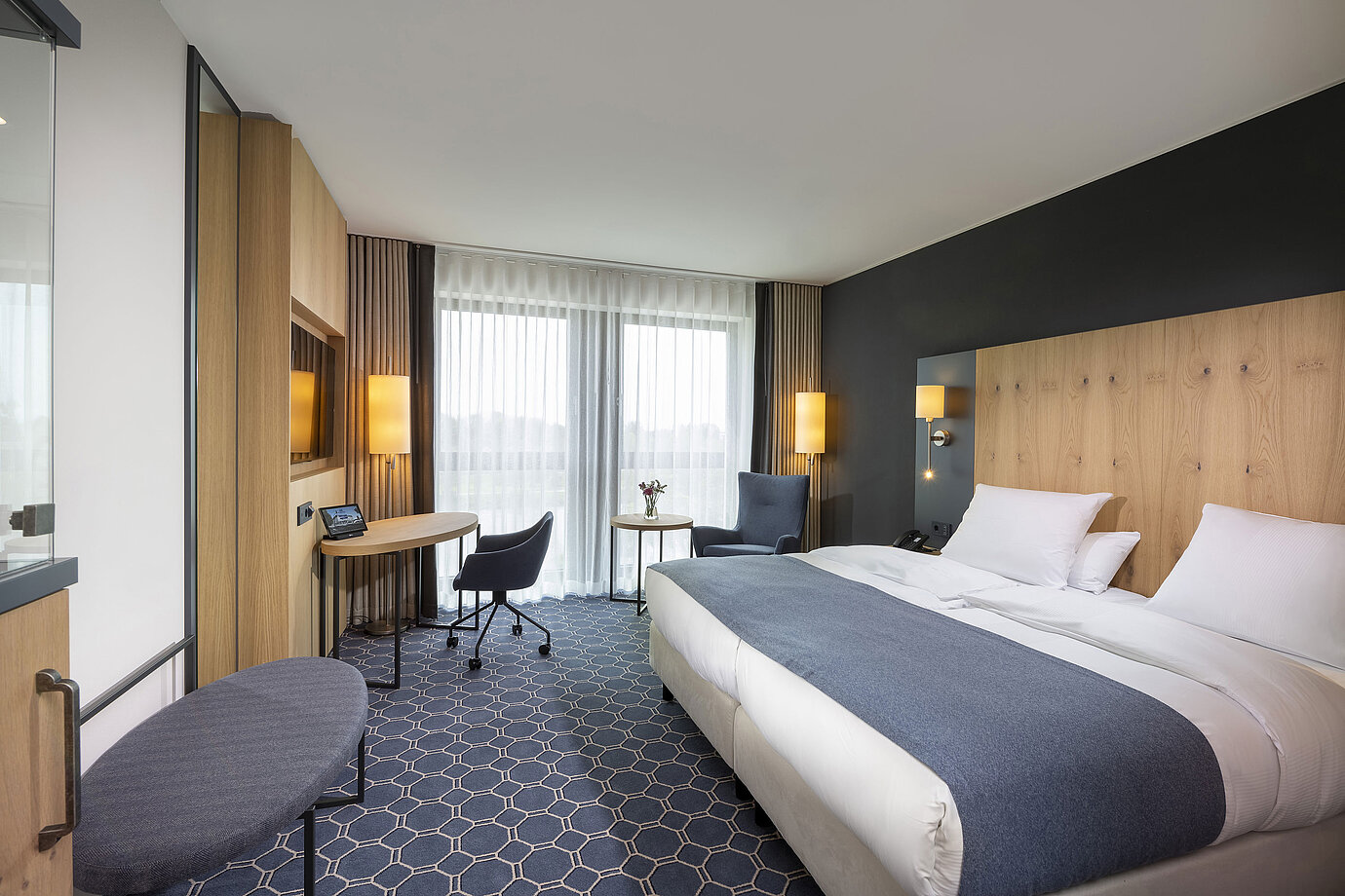 Spacious double room at Maritim Hotel Ingolstadt with desk, seating area, and balcony.