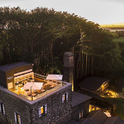 A stylish hotel rooftop terrace with comfortable seating and breathtaking sunset views