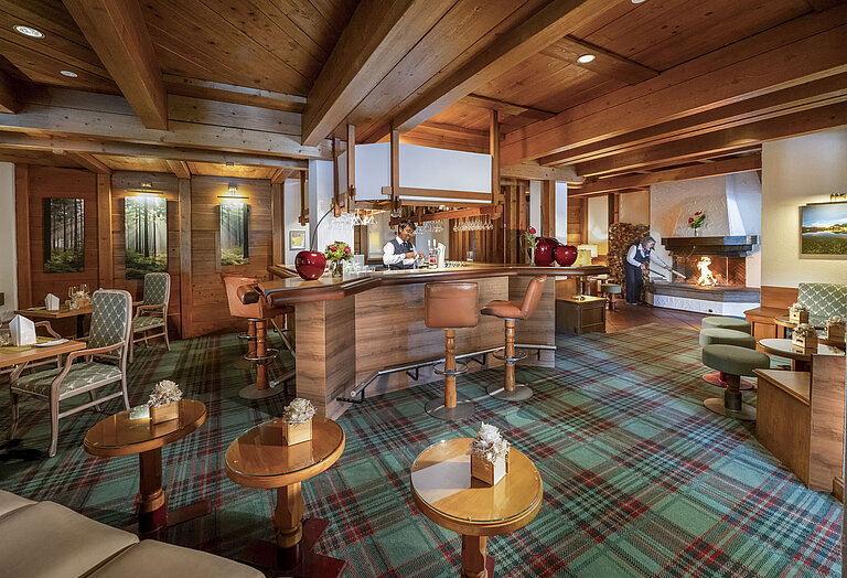 Bar del Maritim Hotel Titisee con barra, techo de madera y chimenea