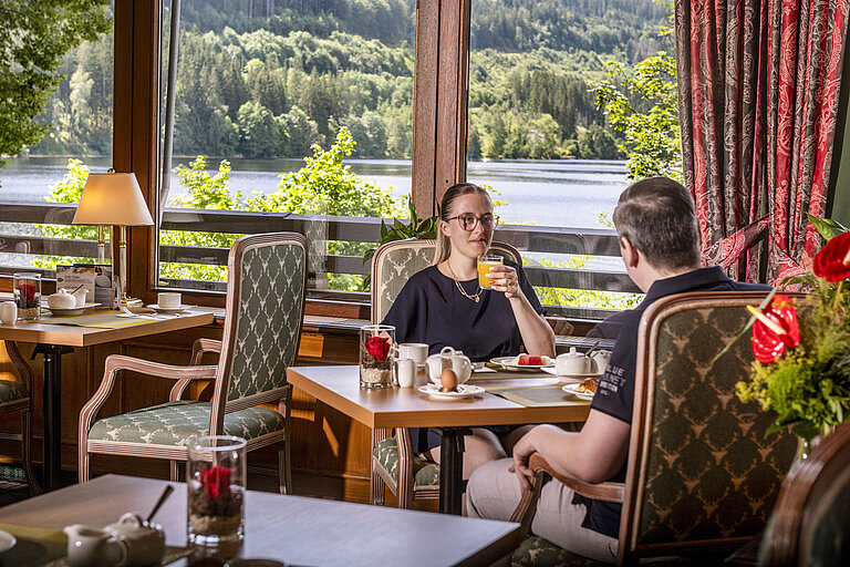 Huéspedes desayunando con vistas al lago en el restaurante del Maritim Hotel Titisee