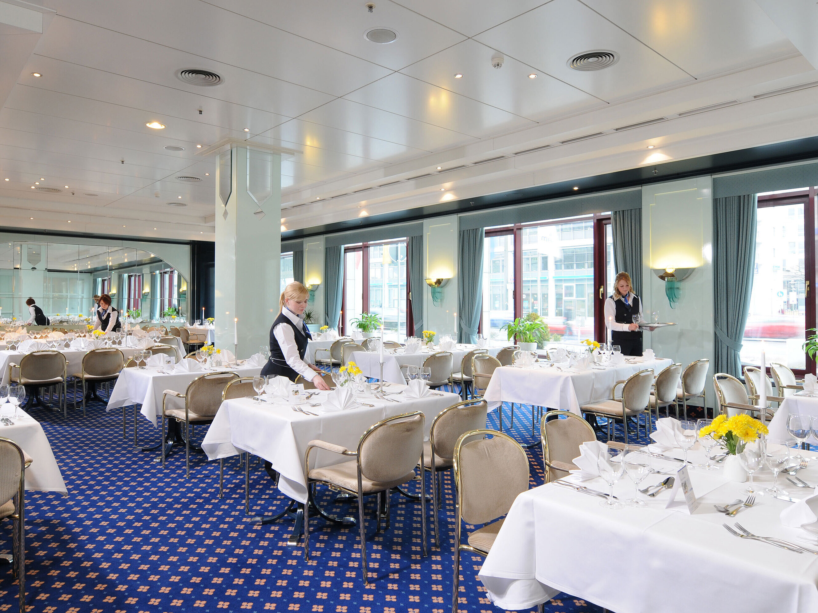 Salon Bonn conference room at Maritim Hotel Magdeburg with white-clothed tables, elegant décor, and friendly service staff.