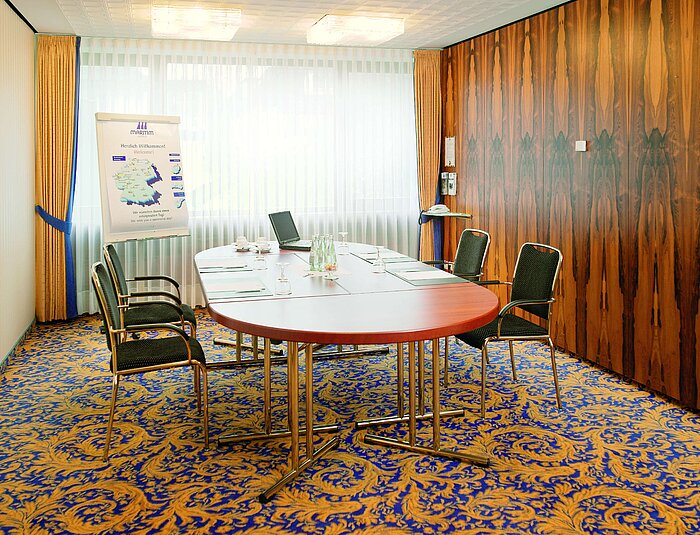 Salle lumineuse avec table de conférence à l’hôtel Maritim Bad Salzuflen
