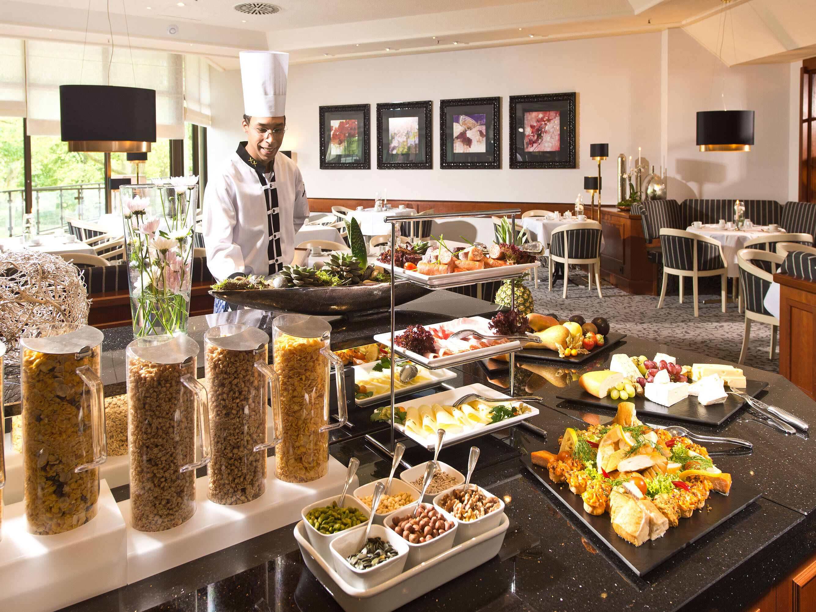 Buffet della colazione all'hotel Maritim Bad Homburg con piatti freschi, cereali e uno chef cordiale