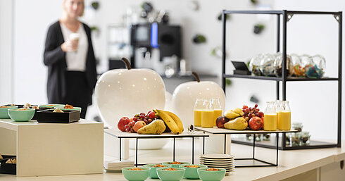 Pausa de conferencia en Maritim Hotel Frankfurt con snacks saludables, frutas frescas y zumo en ambiente relajado.