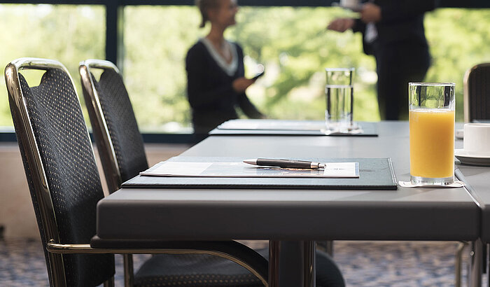 Sala de reuniones moderna con luz natural, portátil, bebidas y ambiente informal en el Maritim Hotel Hannover.