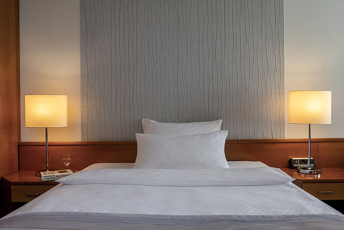 Habitación Superior moderna con cama elegante, mesillas de noche e iluminación suave en el Maritim Hotel Hannover.