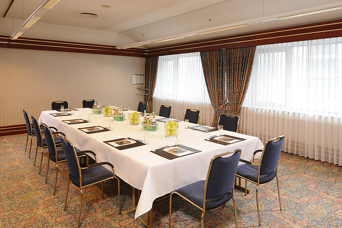 Salle de réunion lumineuse avec sièges en U et décoration fraîche au Maritim Hotel Magdeburg.