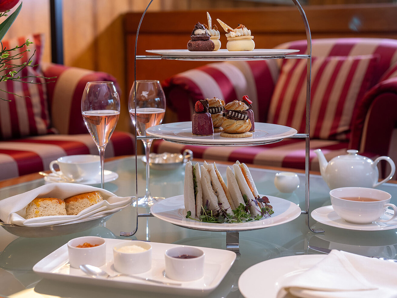 Elegantly laid table with tea, sandwiches and delicate pastries during a classic afternoon tea.