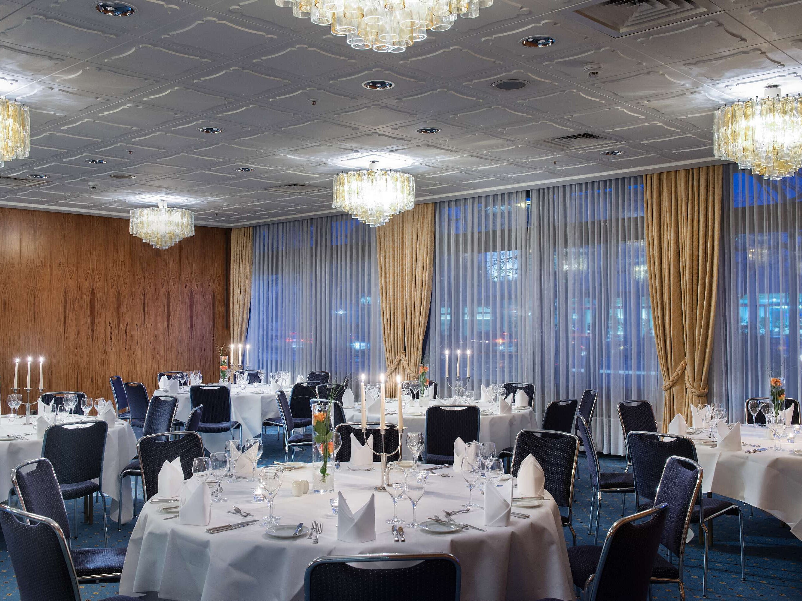 Elegante sala de eventos en el Hotel Maritim Darmstadt con mesas redondas, velas y un ambiente sofisticado.